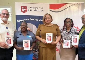 La Ministra Marinka Gumbs le entrega a USM un libro sobre Claude en conmemoración de sus 98 cumpleaños