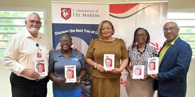 La Ministra Marinka Gumbs le entrega a USM un libro sobre Claude en conmemoración de sus 98 cumpleaños